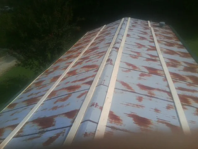 Rusted metal roof panels with new wood purlins before replacement — Storm Damage Roof Repair in Bascom by Roofing Brothers